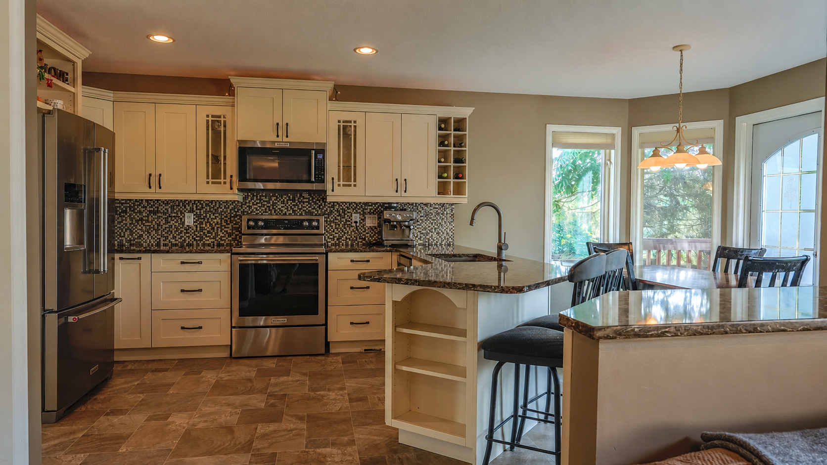 Kitchen with white cabinets, granite, stainless appliances, and breakfast nook