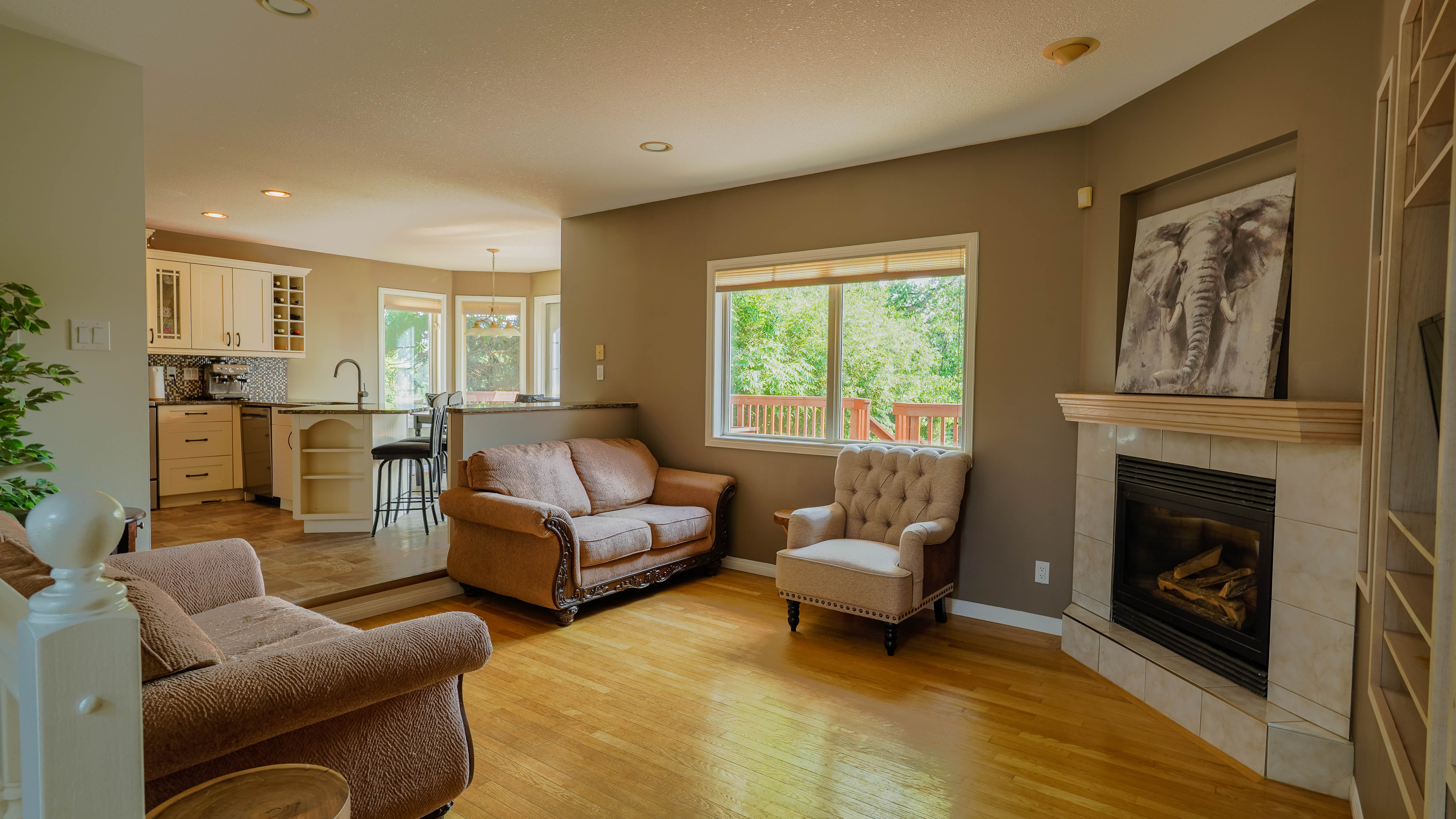Open living room with gas fireplace and kitchen beyond